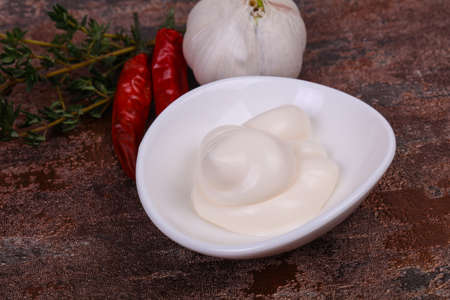 Mayonnaise sauce in the white bowl served thyme, red pepper and garlicの写真素材