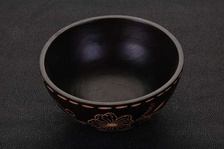 Empty wooden bowl over black backgroundの写真素材