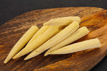 Raw baby corn over the wooden boardの写真素材