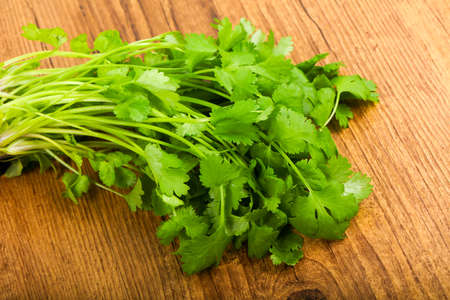 Coriander leaves on a wooden table backgroundの写真素材