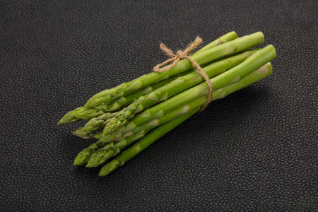 Raw asparagus heap over the wooden boardの写真素材