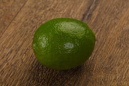 Ripe green lime over the wooden backgroundの写真素材