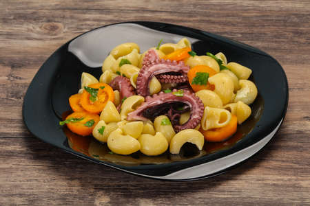 Pasta with octopus, parsley and yellow tomatoesの写真素材