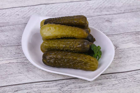 Pickled cucumbers heap in the bowl served basil leavesの写真素材