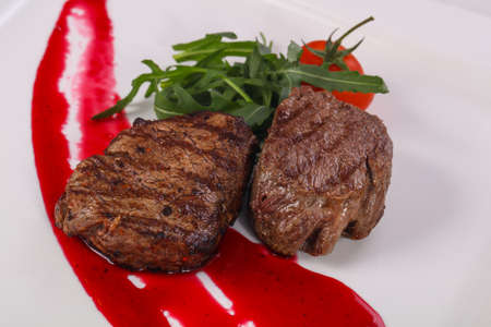 Beef steak with berry sauce served rocket saladの写真素材