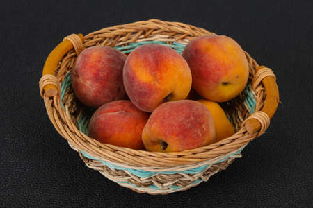 Ripe Peach heap in the wooden basketの写真素材