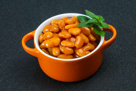 White beans with tomato sauce served basil leaves