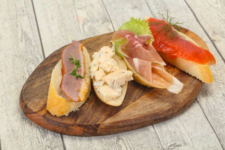 Tapas - bruschetta with prosciutto, salmon, duck and gorgonzola cheeseの写真素材
