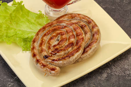 Grilled round pork tasty sausages with sauceの写真素材