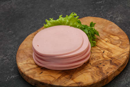 Sliced pork natural sausages over board served basil