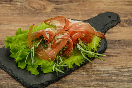 Sliced pork Jamon meat with rosemaryの写真素材