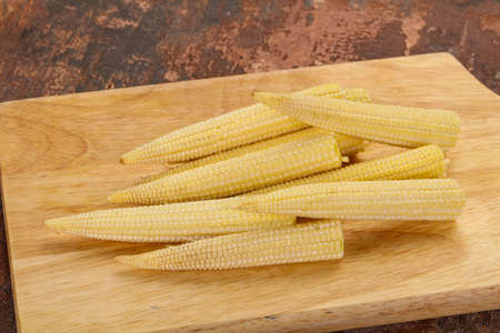Raw baby corn over the wooden boardの写真素材