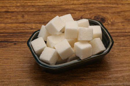Refined white granulated sugar cubs in the bowlの写真素材