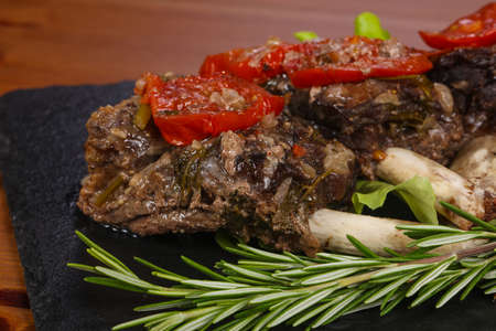 Baked elk meat with tomatoes served rosemaryの写真素材