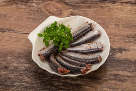 Anchovies fish snack in the bowl served basil leavesの写真素材