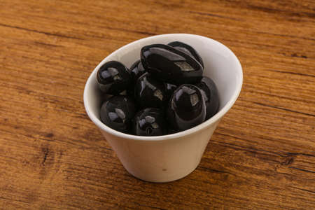 Pickled tasty black olives in the bowlの写真素材