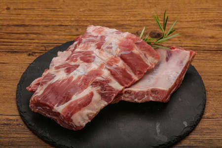 Raw pork ribs served rosemary for cookingの写真素材