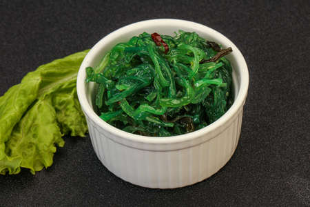 Green Chuka Seaweed Salad Isolated on White Background Top View. Wakame Sea Kelp Salat, Chukka Sea Weed, Healthy Algae Foodの写真素材