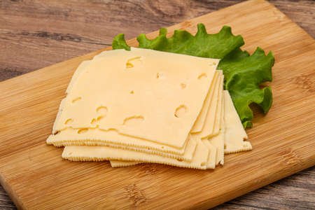Sliced yellow cheese over salad leavesの写真素材