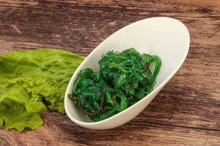 Green Chuka Seaweed Salad Isolated on White Background Top View. Wakame Sea Kelp Salat, Chukka Sea Weed, Healthy Algae Foodの写真素材