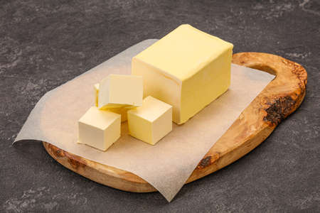 Dairy natural yellow butter piece over boardの写真素材