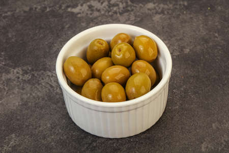 Green pickled olives heap in the bowlの写真素材