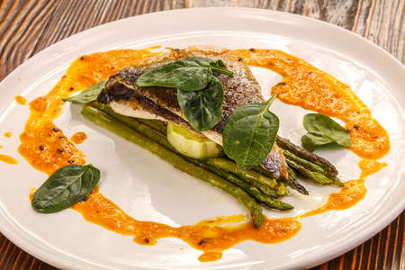 Seabass fish fillet with asparagus and sauceの写真素材
