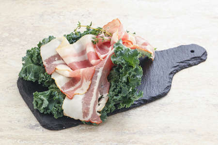 Raw pork bacon over board for snackの写真素材