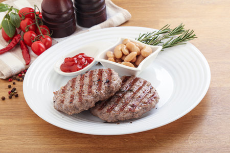 Grilled beef burger cutlet with sauce and beans