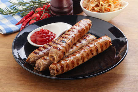 Grilled sausages with cabbage and tomato sauceの写真素材