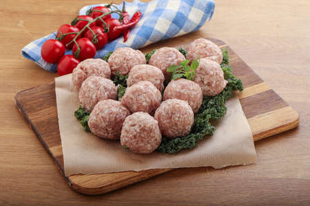 Raw pork meatball for cooking over boardの写真素材