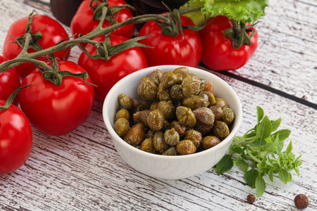 Marinated green capers condiment in the bowl