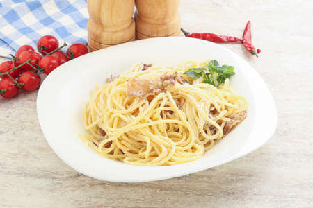 Spaghetti carbonara pasta with bacon served basil leavesの写真素材