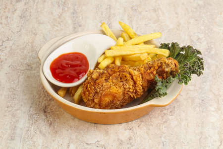 Crispy chicken leg with fry potato and sauceの写真素材