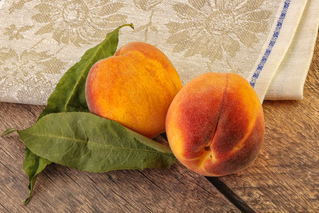 Peaches with leaves on wooden table, healthy food and nutrition conceptの写真素材