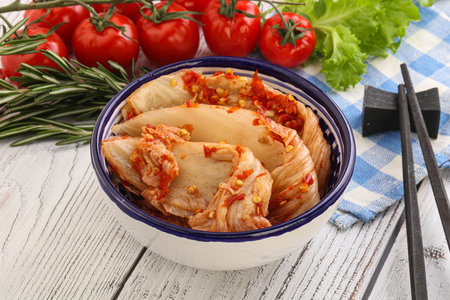Kimchi cabbage with red pepper and rosemary on a white wooden backgroundの写真素材