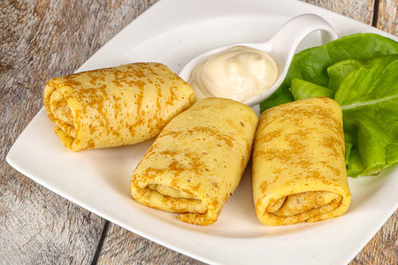 Stuffed homemade pancakes with cream sauceの写真素材