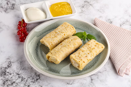 Homemade stuffed sweet pancakes with honey and cream sourの写真素材