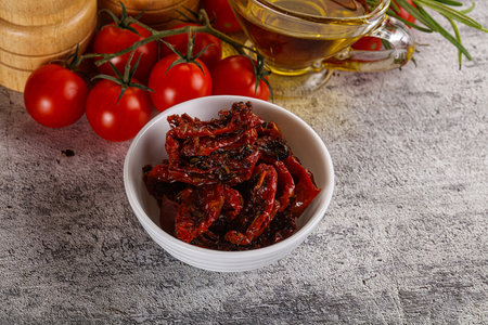 Homemade dry tomatoes with oil and herbsの写真素材