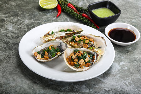 Open half oysters with green onion and peanutの写真素材