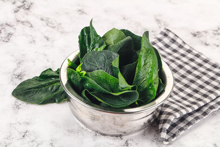 Ripe green spinach leaves heap in the bowlの写真素材