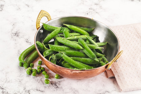 Sweet young green peas heap in the bowlの写真素材