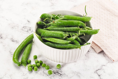 Sweet young green peas heap in the bowlの写真素材