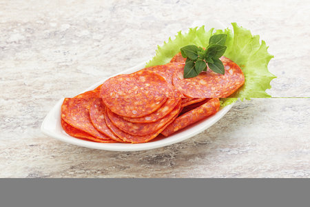 Sliced pepperoni salami sausage in the bowlの写真素材