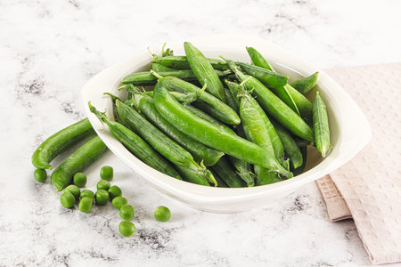 Sweet young green peas heap in the bowlの写真素材
