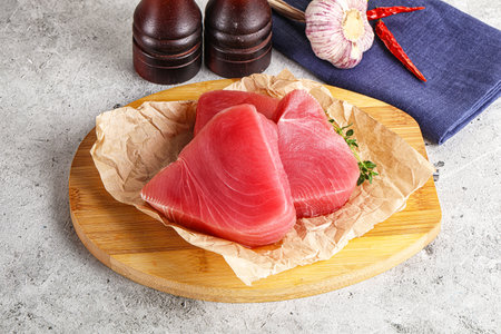 Delicous raw tuna steak for cooking over boardの写真素材