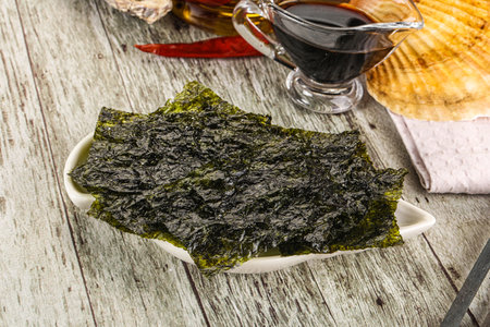 Vegan snack Green nori seaweed chips with soya sauceの写真素材