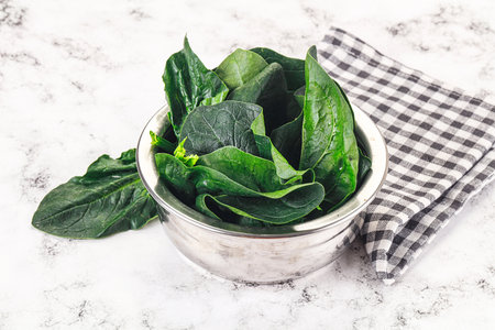 Ripe green spinach leaves heap in the bowlの写真素材