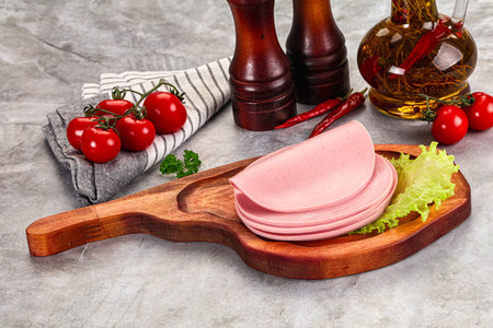 Sliced boiled sausage heap over boardの写真素材