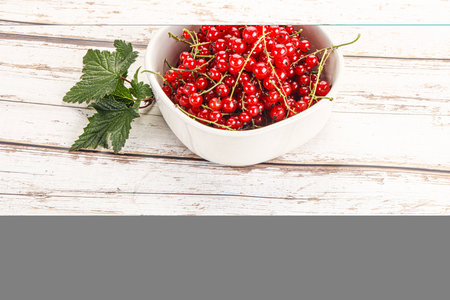 Sweet ripe red currant berries in the bowlの写真素材